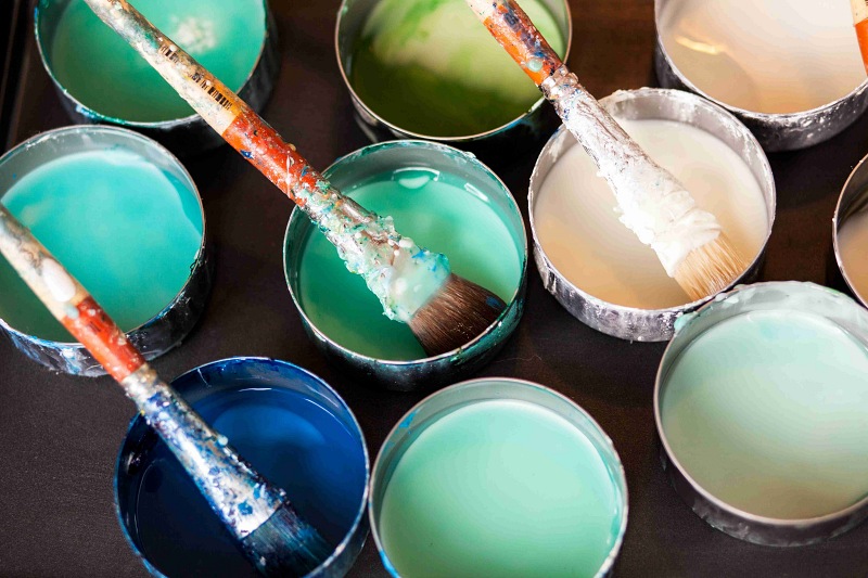 different coloured paint tins and brushes
